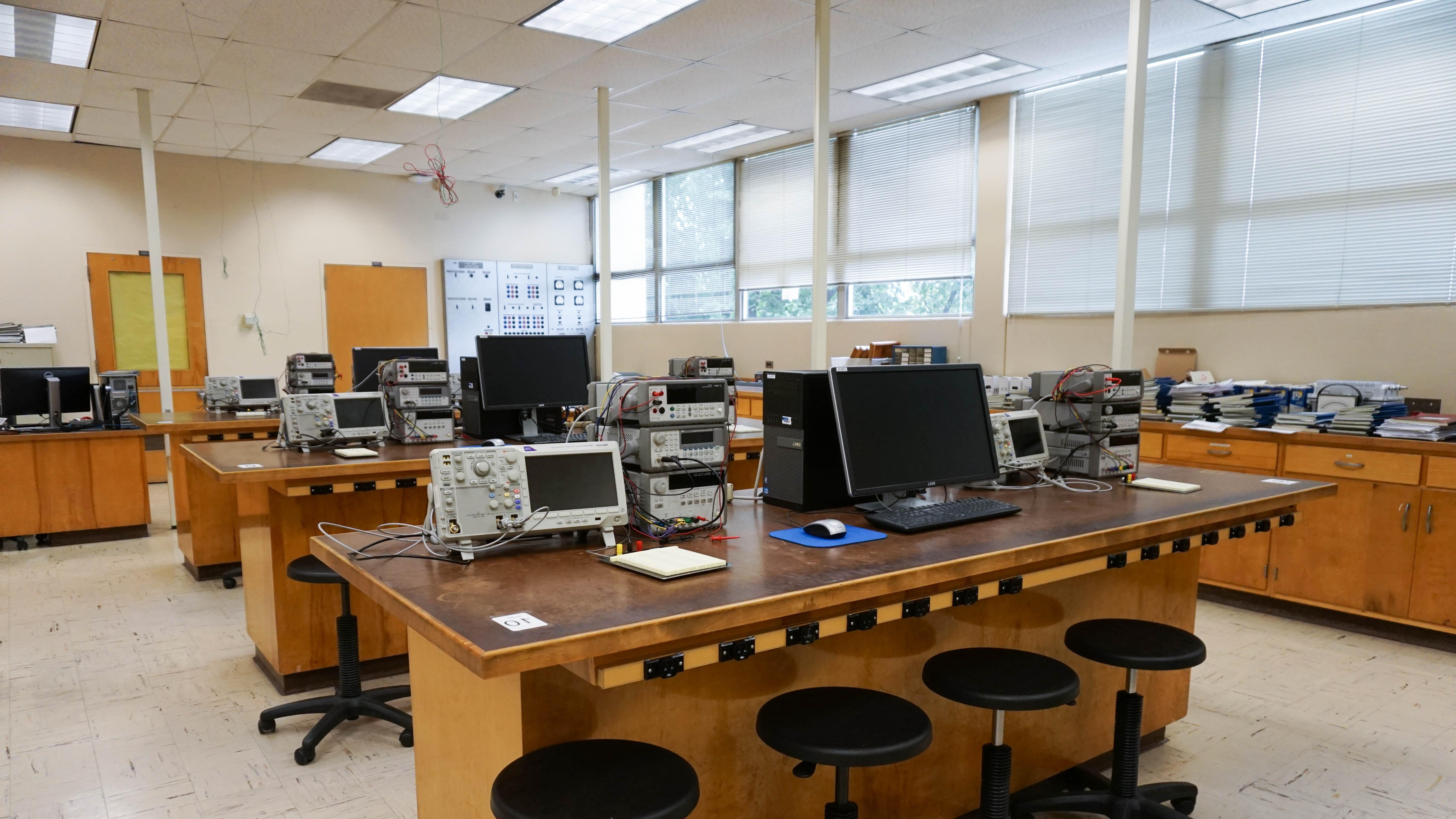 实验室的一张木桌，上面有四个凳子，供学生使用设备.
