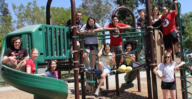 Photo of a group of students on a jungle gym in a playground.